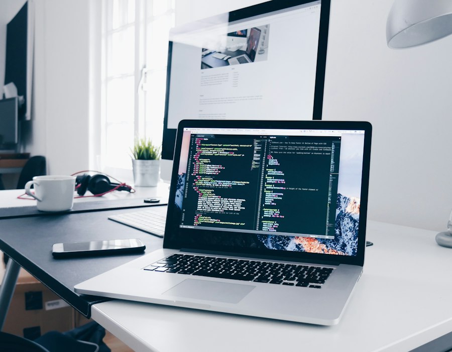 Portátil con código en pantalla sobre un escritorio claro
